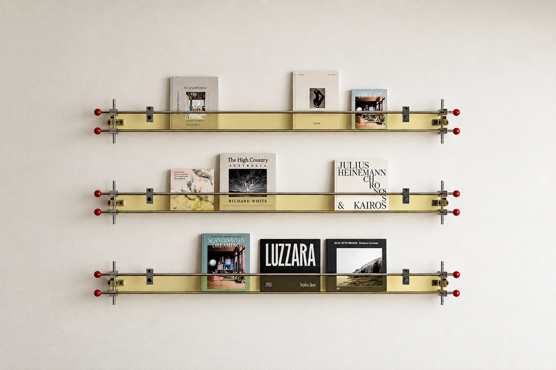 Wall-mounted display shelves with books, gold-tone trays and metal rails